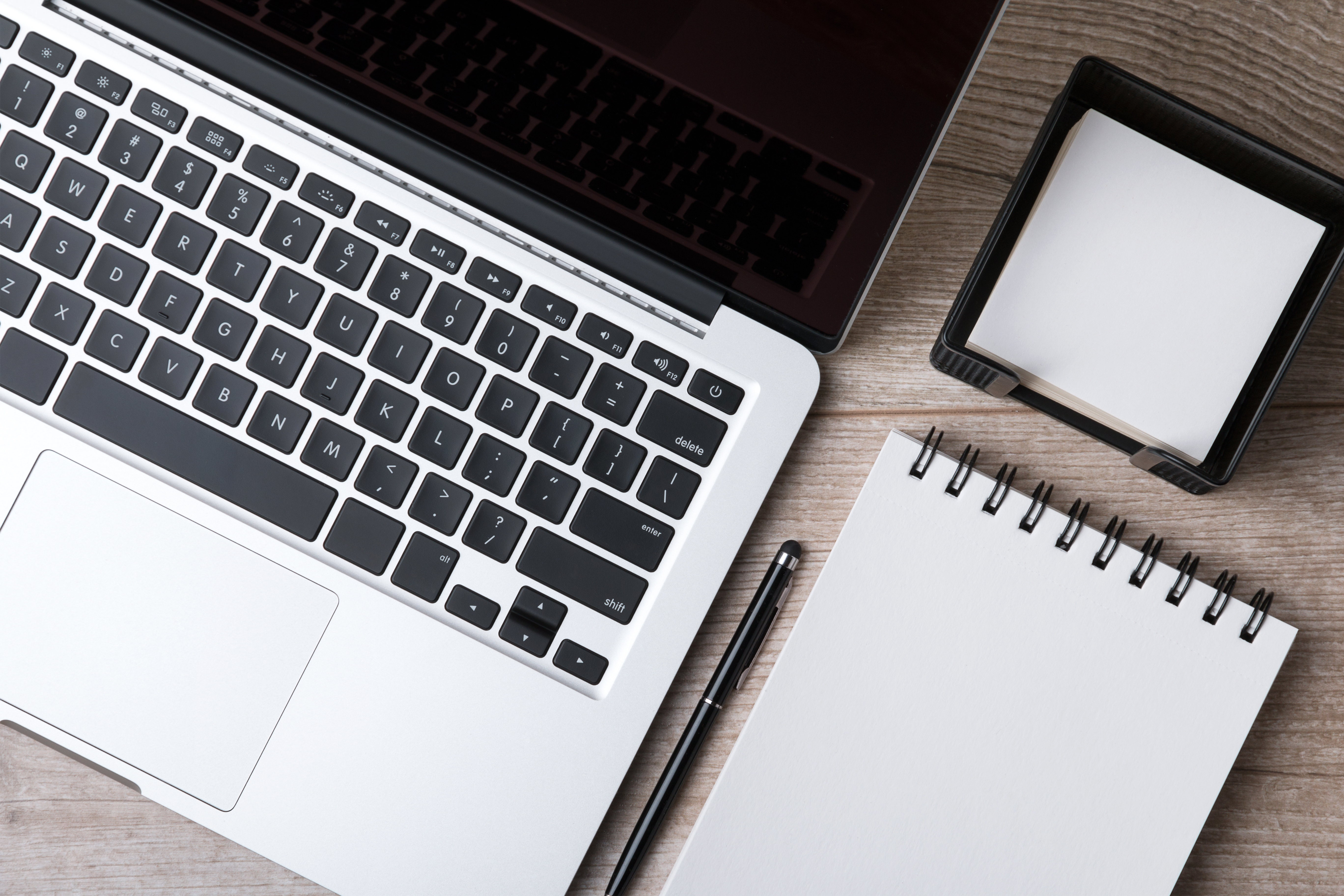 A laptop, notepad and sticky notes